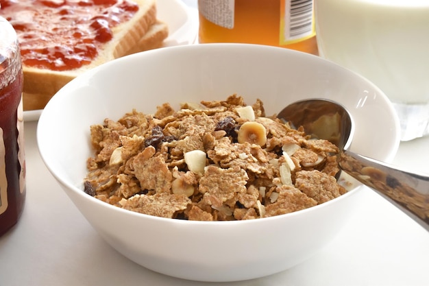 Fruit and fiber cereal with spoon in a white bowl