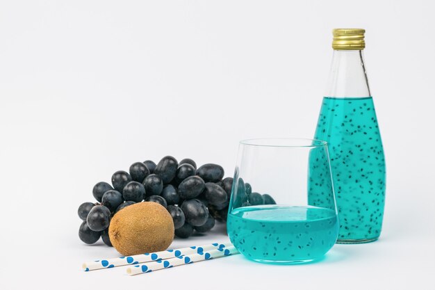 Fruit, fles en cocktailglas op een lichte ondergrond