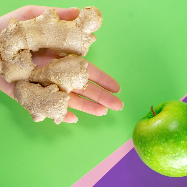 Fruit green apple ginger on colored background hands juice\
tasty