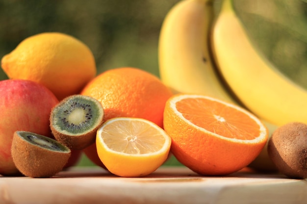 자연 배경에서 과일 수확입니다. 오렌지, 키위, 레몬, 사과, 바나나, 일부는 잘라