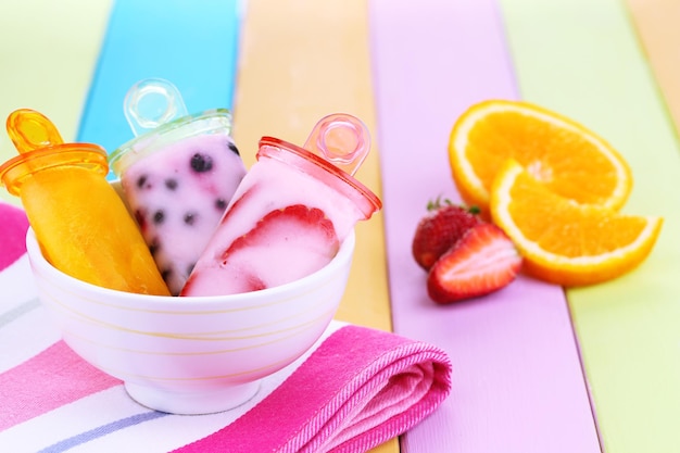 Fruit ice cream in bowl on wooden table closeup