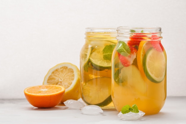 Fruit ice tea and ginger herbal ice tea with mint in a glass jars