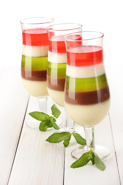 Fruit jelly in glasses and mint on wooden table