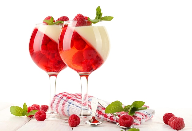 Fruit jelly with raspberries in glasses on wooden table