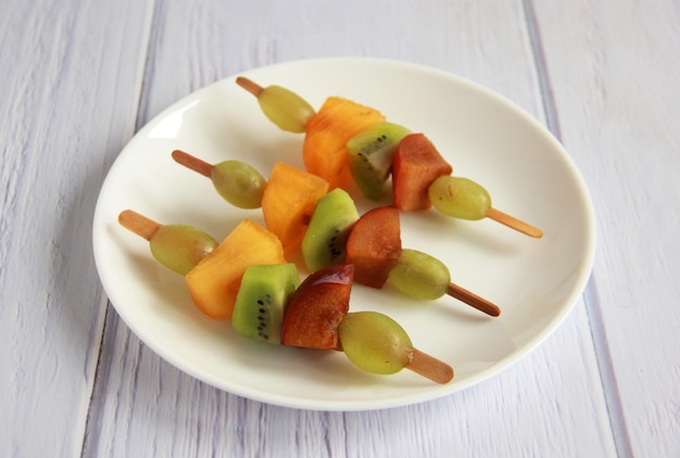 Foto spiedini di frutta su spiedini di legno - spuntino sano per i bambini