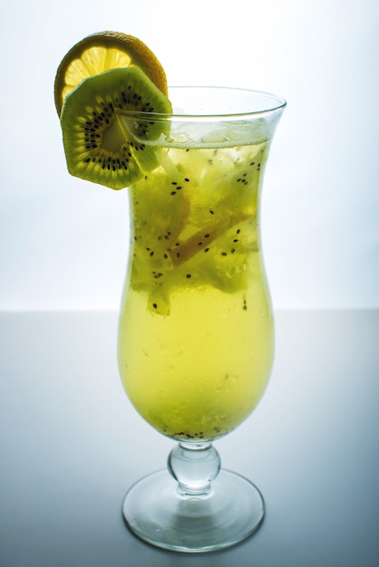 Fruit lemonade in hurricane glass with kiwi and lemon