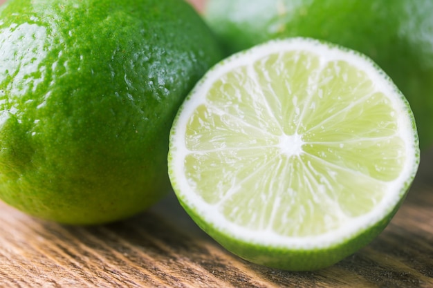 Fruit lime with lime slices over wooden. Citrus fruit.