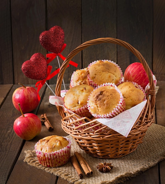 Fruit muffins with nutmeg and allspice in a wicker basket on a wooden background