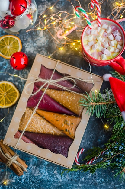 Fruit pastila fruit leather cones in a gift box and  cup cocoa