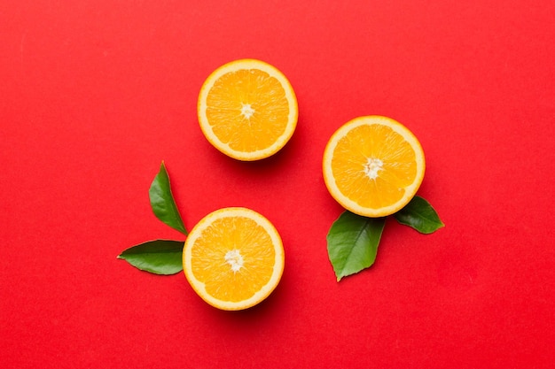色付きの背景に新鮮なオレンジスライスのフルーツパターン上面図コピースペース創造的な夏のコンセプト最小限のフラットレイで柑橘類の半分