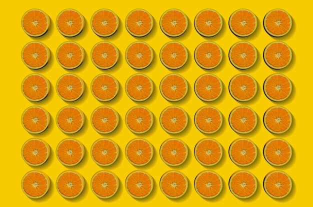 Фото Фруктовый образец свежих апельсиновых дольок на желтом фоне. вид сверху. копировать пространство. поп-арт