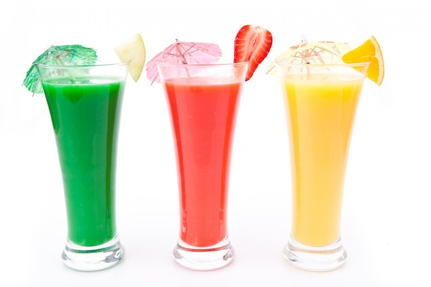 Fruit pieces and cocktail umbrella in a row of glasses