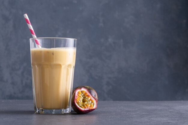 Fruit protein shake on a concrete background. Fresh milkshake with passion fruit. A glass of protein shake.