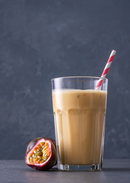 Fruit protein shake on a concrete background. Fresh milkshake with passion fruit. A glass of protein shake.