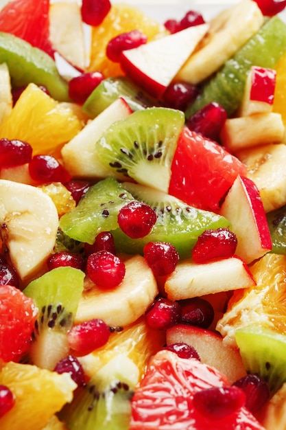 背景として、フルスクリーンでのフルーツサラダのクローズアップ。新鮮で健康的な果物のスライス