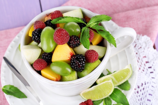 Fruit salad in cup on napkin on wooden table