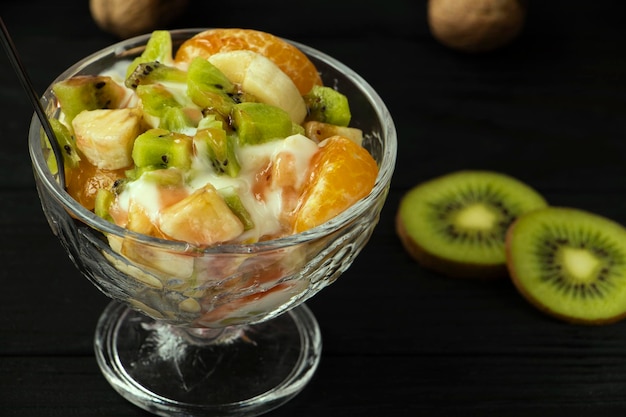 fruit salad in a glass bowl Kiwi banana and tangerine with yoghur fruit topping A healthy snack