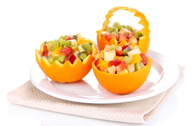 Fruit salad in hollowed-out orange isolated on white