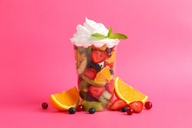 Fruit salad in takeaway cup on pink