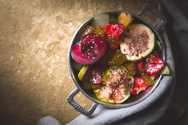 Fruit salad with figs plum and pear in a tin bowl