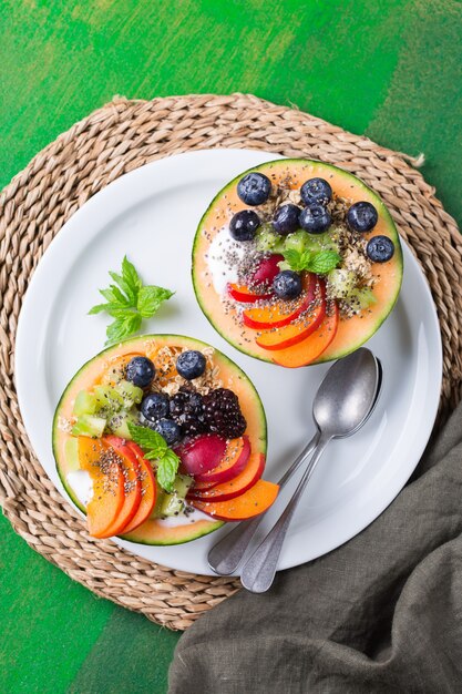 Fruit salad with yogurt in carved melon cantaloupe bowl