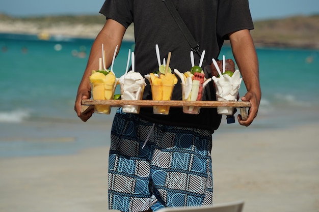 メキシコの砂浜で販売のための果物のセールスマン