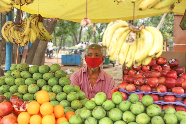 Foto un frutto che vende frutta con maschera da indossare