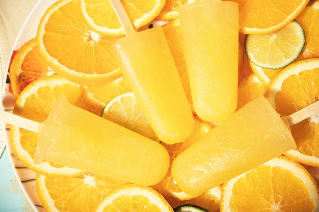 Fruit sinaasappel citrus ijslollys ijs pops en plakjes sinaasappel Bovenaanzicht