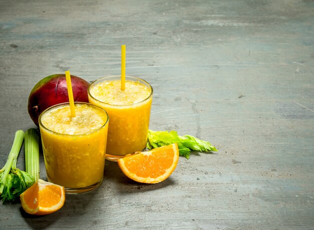 Fruit smoothie in glasses on rustic table.