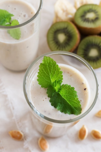 Fruit smoothie in glazen met munt, melk en kiwi