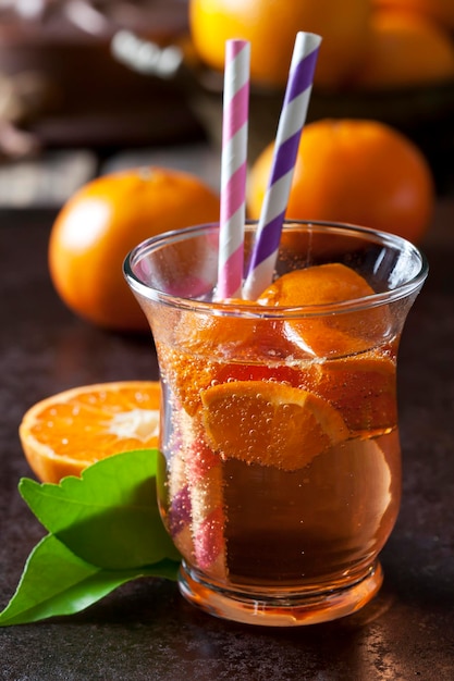 Fruit spritzer of tangerines in a glass with drinking straws