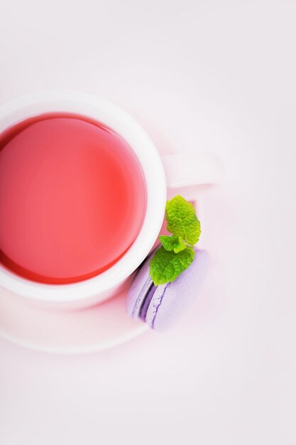 Фруктовый чай ежевичный макарон с листом мяты на розовом фоне копией пространства