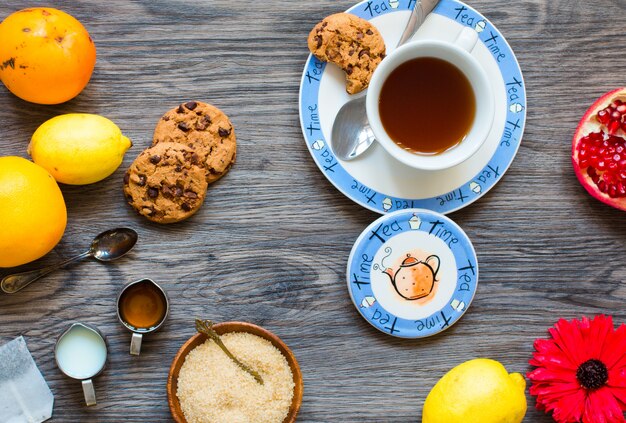 Photo fruit tea with lemon milkhoneyorange pomegranate on a wooden background