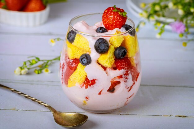 Fruit trifle with pound cake and yogurt in glass with spoon.