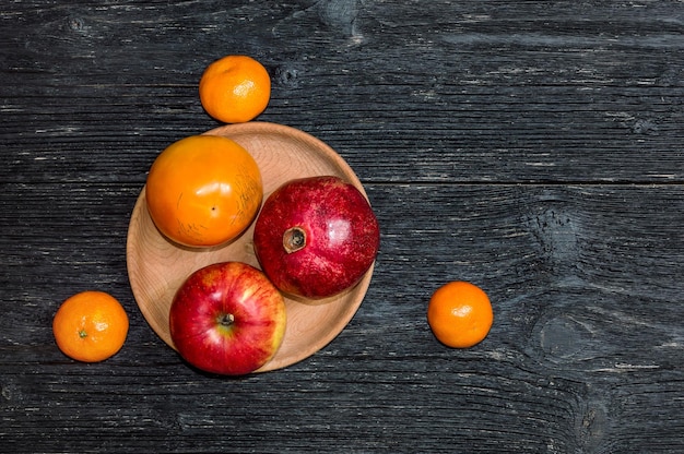 Fruit in wooden plate on the table. Top view