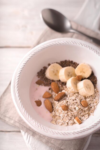 Fruit yogurt with different toppings on the white wooden table top view