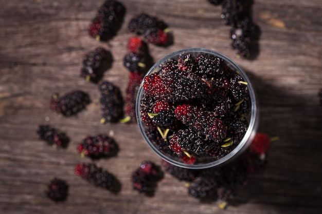 fruit zwarte moerbei in glas op hout achtergrond