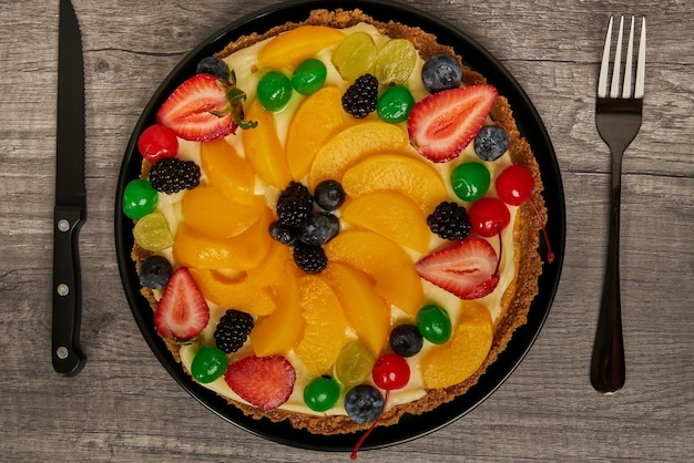 Fruitcake met aardbeien, bosbessen, kersen en perziken bovenaanzicht