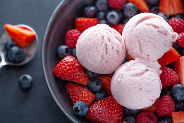 Fruitige aardbeien-ijslepels geserveerd op bord met fruit. Bovenaanzicht.