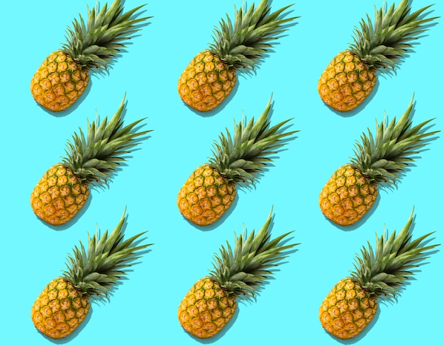 Fruitpatroon met verse organische ananas met harde schaduwen op helder azuurblauw patroon. Bovenaanzicht, platliggend, minimalistisch ontwerp.