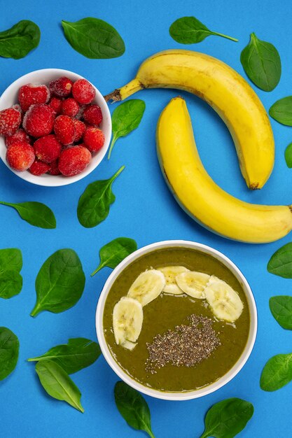 Fruits and berries on a bright blue background a set of banana spinach leaves and strawberry
