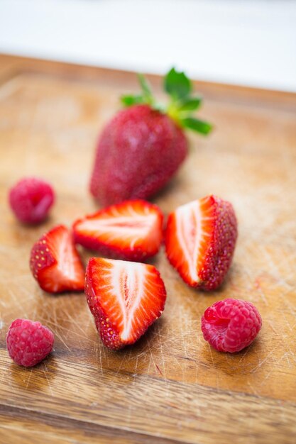 fruits, berries, diet, eco food and objects concept - close up of fresh ripe red strawberries on cutting board