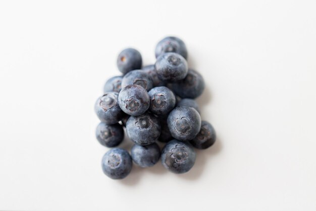 fruits, berries, diet, eco food and objects concept - juicy fresh ripe blueberries on white