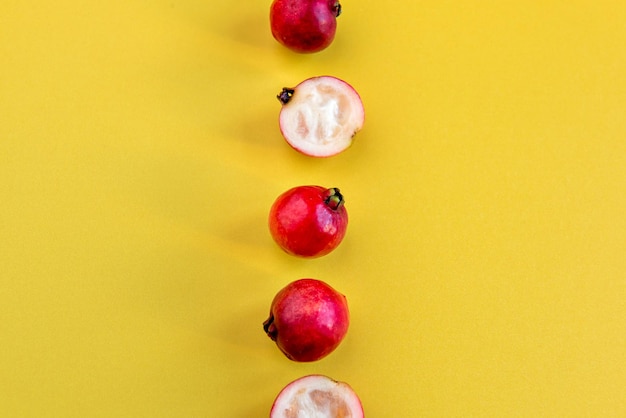 Fruits Cattley guava red fruits Psidium cattleyanum on yellow background