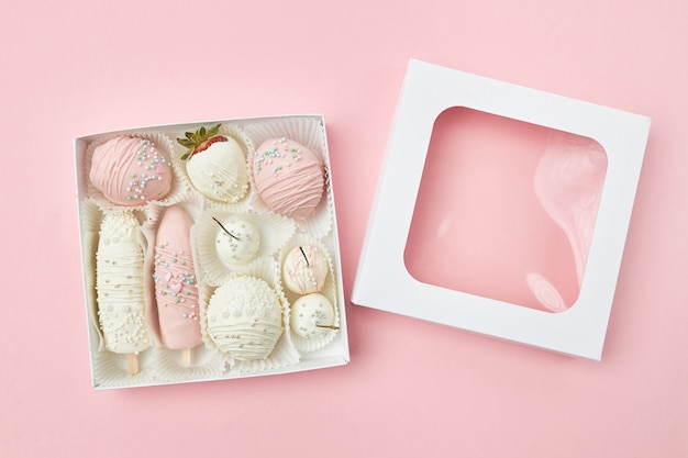 Fruits coated with white and pink chocolate