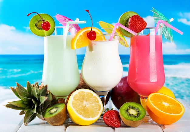 Cocktail di frutta con frutta fresca su una spiaggia