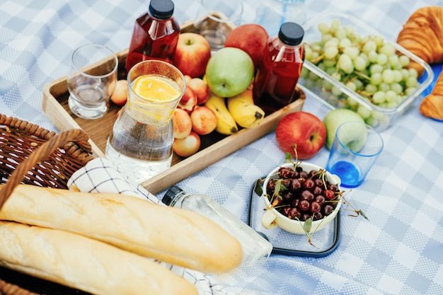 fruits and drinks on the tablecloth at the picnic summer family vacation in nature