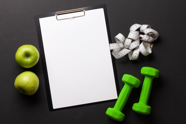 Photo fruits dumbbells and blank sheet for your plan or goals