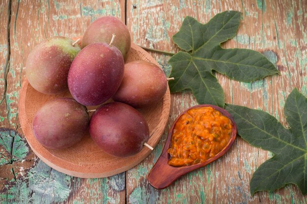 Fruits of gulupa on vine wood table Passiflora pinnatistipula