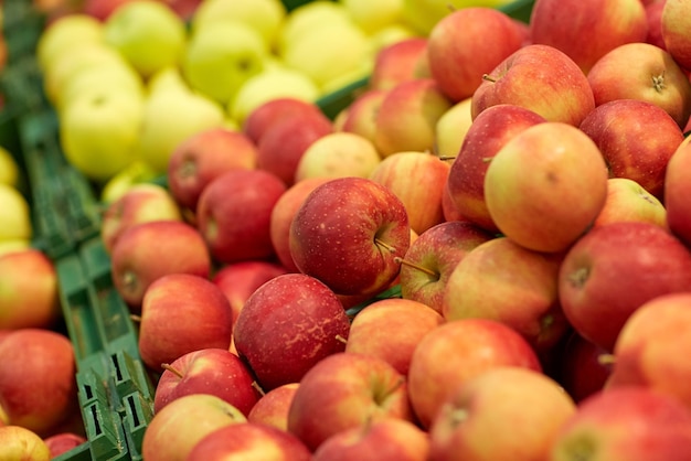 fruits, harvest, food and sale concept - ripe apples at grocery store or market